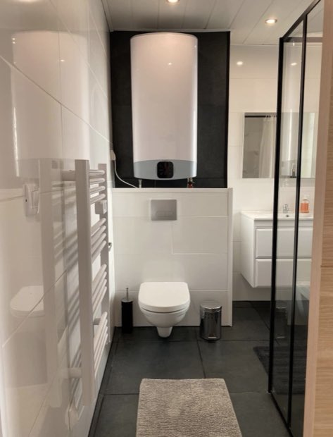 Salle d'eau avec ballon d'eau chaude Ariston, WC suspendu et sèche-serviettes